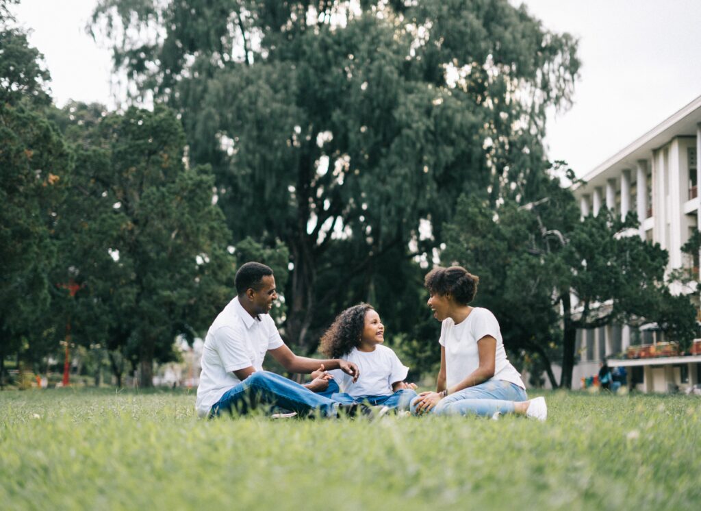 parents with child sitting in the grass