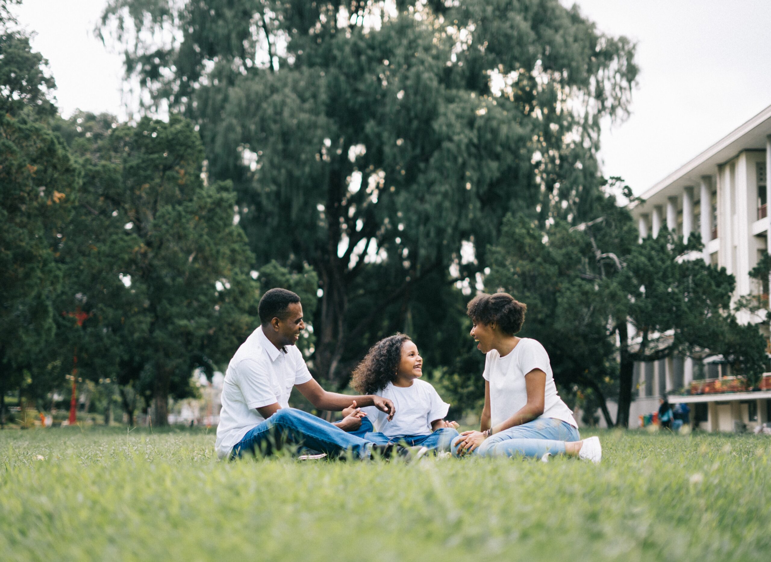 parents with child sitting in the grass